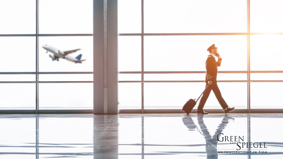 Pilot walking in airport, airplane flying behind.