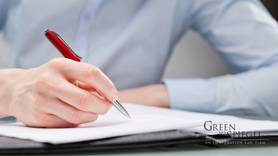 Man holding pen writing on paper.