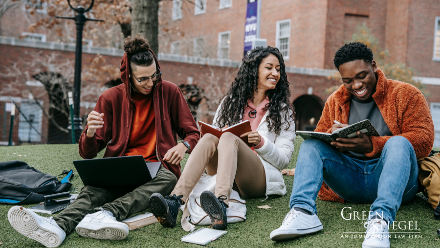 International students doing school work on grass